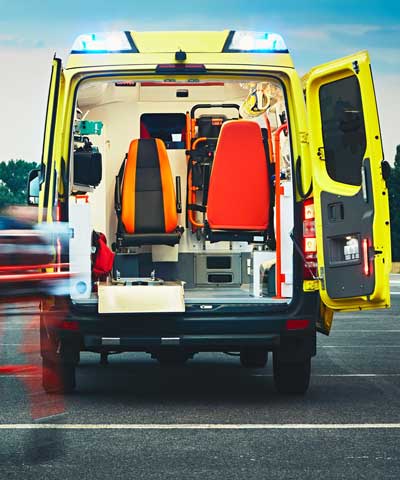 Paramédico a caminho de uma ambulância amarela para socorrer alguém